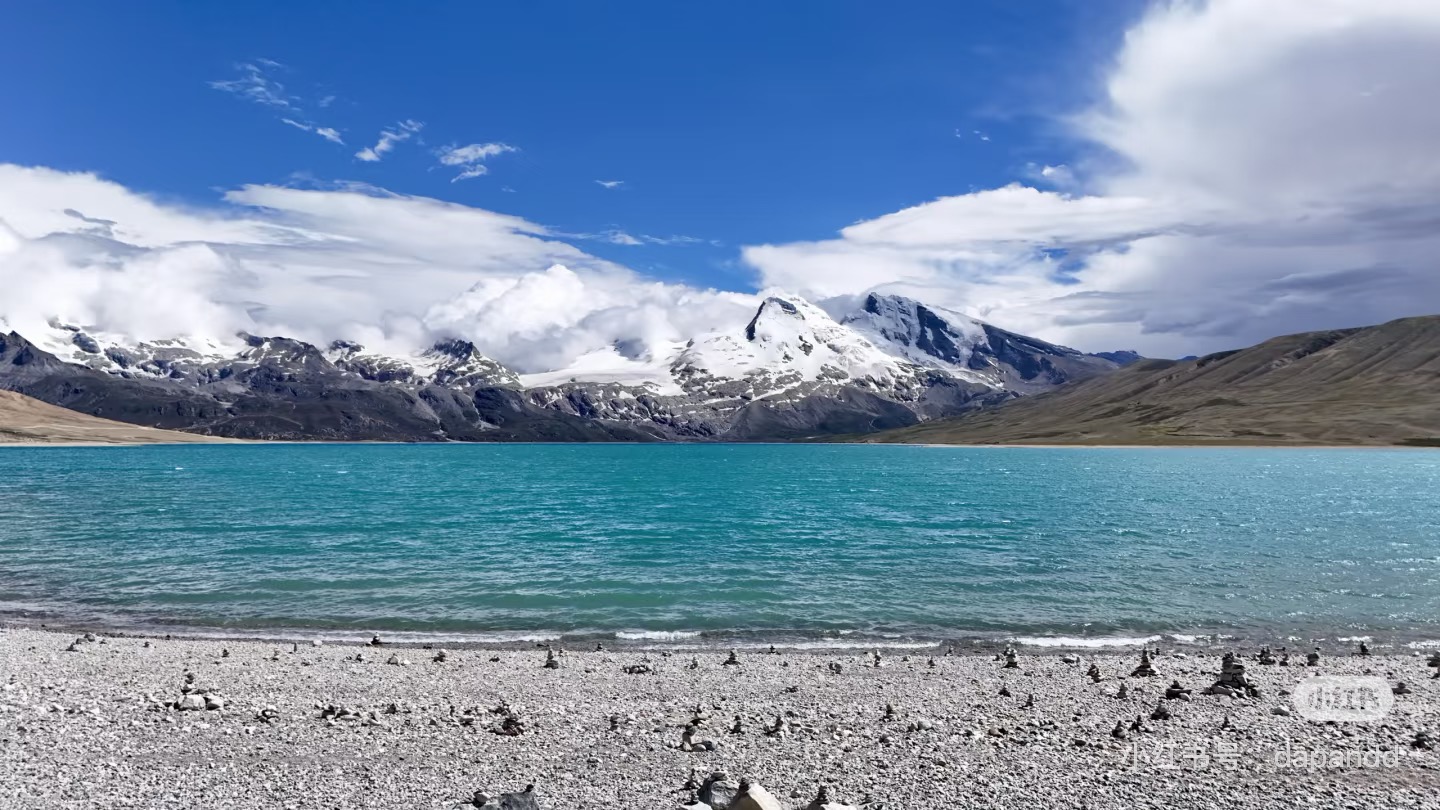 A high-altitude lake beneath snow-capped mountains